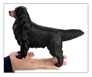 Detailed close-up of a 22cm realistic black retriever dog model held in hand