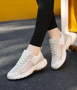 Dettaglio del tessuto a rete traspirante e suola antiscivolo di scarpe da corsa bianche