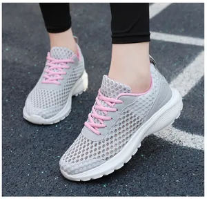 Dettaglio della maglia grigia traspirante e finiture rosa su scarpe da corsa leggere