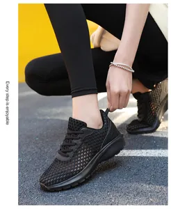 Dettaglio scarpa da corsa in mesh nero traspirante con lacci su pista all'aperto