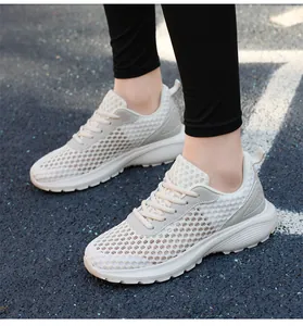 Dettaglio della tomaia in mesh traspirante e suola spessa delle scarpe da corsa bianco crema