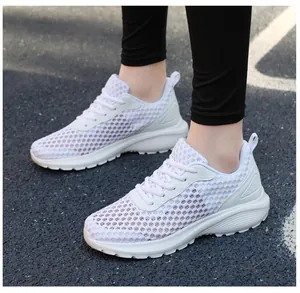 Dettaglio scarpe da corsa in mesh bianco leggero su pista blu per un comfort traspirante