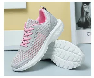 Dettaglio scarpe da corsa in mesh grigio con lacci rosa e suole in gomma spessa