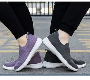 Detail view of purple and grey breathable flyknit walking shoes on outdoor pavement