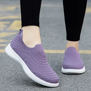 Purple breathable fly-knit slip-on walking shoes with white soft soles on asphalt