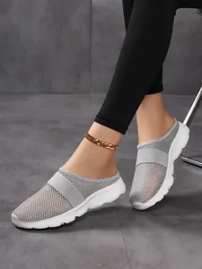 Macro detail of grey mesh breathable upper and elastic strap on wedge mule shoe