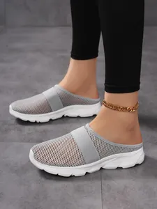Detail view of breathable grey mesh upper and white platform sole on mule sneakers