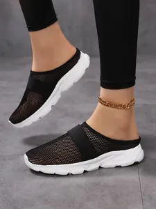 Detail view of breathable black mesh upper and thick white wedge sole on mule sneakers