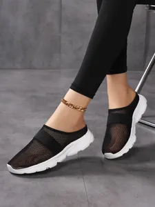 Detail of breathable black mesh upper and thick white sole on wedge mule shoes