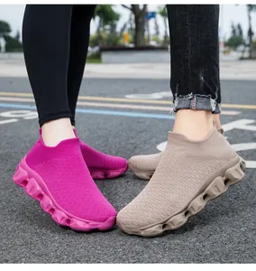 Close-up of rose red and khaki breathable knitted sock sneakers on asphalt street
