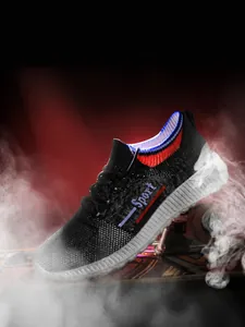 Makro-Detail von atmungsaktivem schwarzem Mesh-Gewebe und Sport-Text auf Herren-Sneakern
