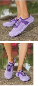 Vista dettagliata di scarpe da scoglio in rete viola con lacci elastici su rocce esterne