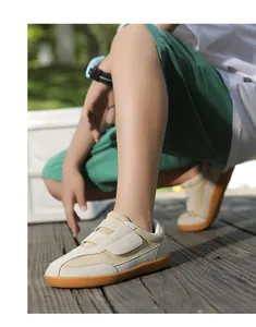 Close-up of children's retro sneakers with beige mesh, suede panels and rubber soles