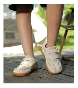 Detail of retro kids sneaker with double hook-and-loop straps on a wooden outdoor deck