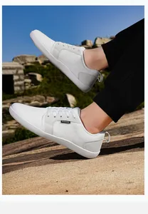 Detailaufnahme weißer atmungsaktiver Mesh-Sneaker mit Fashion-Label auf felsigem Gelände