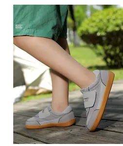 Close-up of kids retro mesh sneakers with double velcro straps and rubber soles on grass
