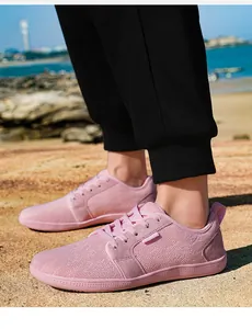 Nahaufnahme von rosa atmungsaktiven Mesh-Sneakern mit Gummisohle vor Strandhintergrund