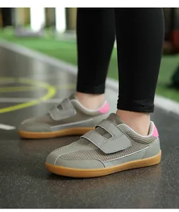 Low-angle view of kids retro grey sneakers with double velcro straps and gum rubber sole