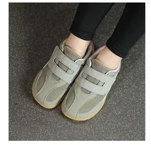 Detail of grey kids trainer with mesh upper and double hook-and-loop straps
