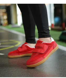 Detail view of red kids retro sneakers with dual hook-and-loop straps and gum soles