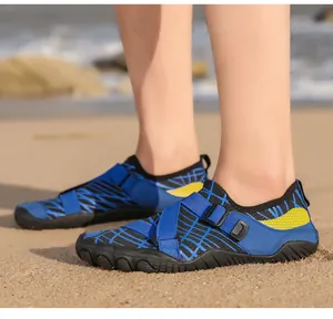 Detail of blue outdoor water shoes with yellow honeycomb pattern on sandy beach background