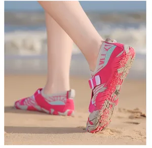 Detail of rose red quick-dry water shoes with non-slip soles on a sunny beach