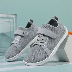 Close-up of gray kids sneakers with mesh knit upper and secure velcro strap closure