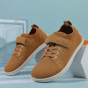 Detail of tan mesh toddler shoes featuring a hook-and-loop strap and non-slip white rubber sole