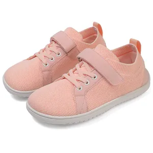 Detail view of pink knit sneakers with velcro strap and breathable fabric texture