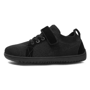 Detail of kids black wide-toe flyknit sneaker with velcro and mesh texture