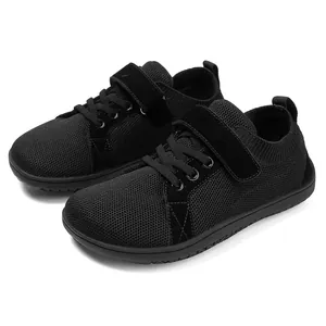 Detail of kids black barefoot shoes showing breathable mesh and velcro closure