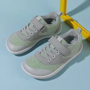 Detail view of grey mesh toddlers sneakers with green accents and anti-slip rubber toe cap