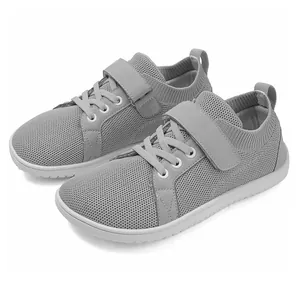 Detail view of grey breathable mesh kids sneakers with Velcro strap and rubber soles