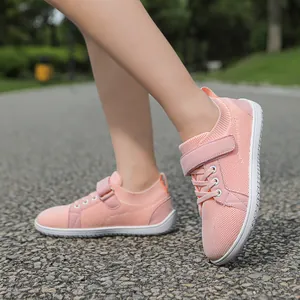 Detail of pink mesh kids sports shoe with velcro strap and breathable fabric texture