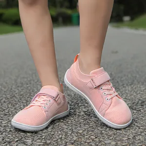 Detailed view of pink mesh kids sneaker with hook and loop strap on park pebble path