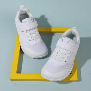 Detailed top view of white kids sneakers with velcro straps and breathable mesh
