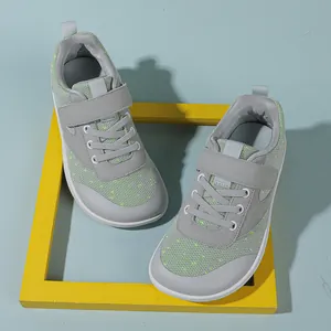Detailed top view of grey baby sneakers with velcro strap and vibrant green mesh accents