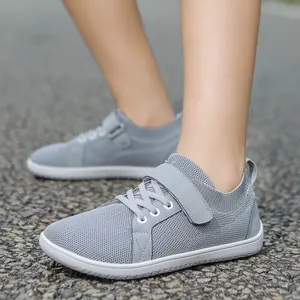 Detail of grey breathable mesh kids sneaker with adjustable hook and loop strap