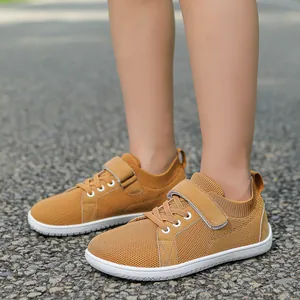 Kids wide-fit ginger yellow mesh sneaker with hook and loop closure on outdoor gravel