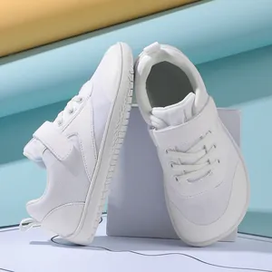 Close-up of white barefoot style toddler shoes with breathable mesh and velcro straps
