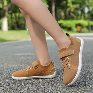 Detail of tan kids athletic shoe with breathable mesh upper and velcro strap in park setting