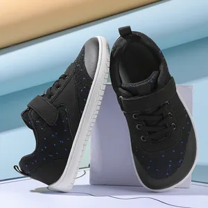 Detail of children's wide-toe sneakers with blue polka dots and secure velcro strap