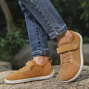 Close-up of kids breathable ochre mesh sneakers with velcro strap on natural rocks