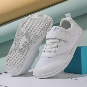 Detail of white wide-toe toddler sneakers with anti-slip rubber sole and velcro straps