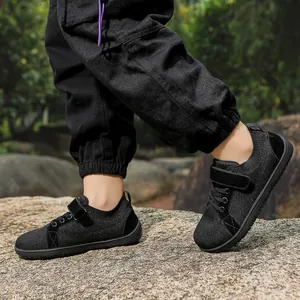 Kids barefoot sneakers showing wide toe box and breathable mesh on a rock outdoor