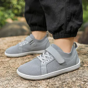 Detail of grey mesh kids' sneakers featuring convenient velcro straps and lace-up design