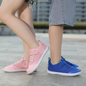 Detail of pink and blue breathable mesh toddler shoes with Velcro on outdoor stone floor