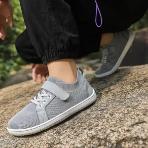 Detail of breathable grey mesh sneakers with Velcro straps on natural rocky terrain