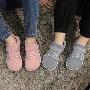 Detail of pink and grey mesh kids sneakers with velcro straps on outdoor rocks