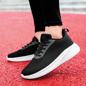 Vue latérale de chaussures de course en maille noire avec semelles blanches à amorti épais